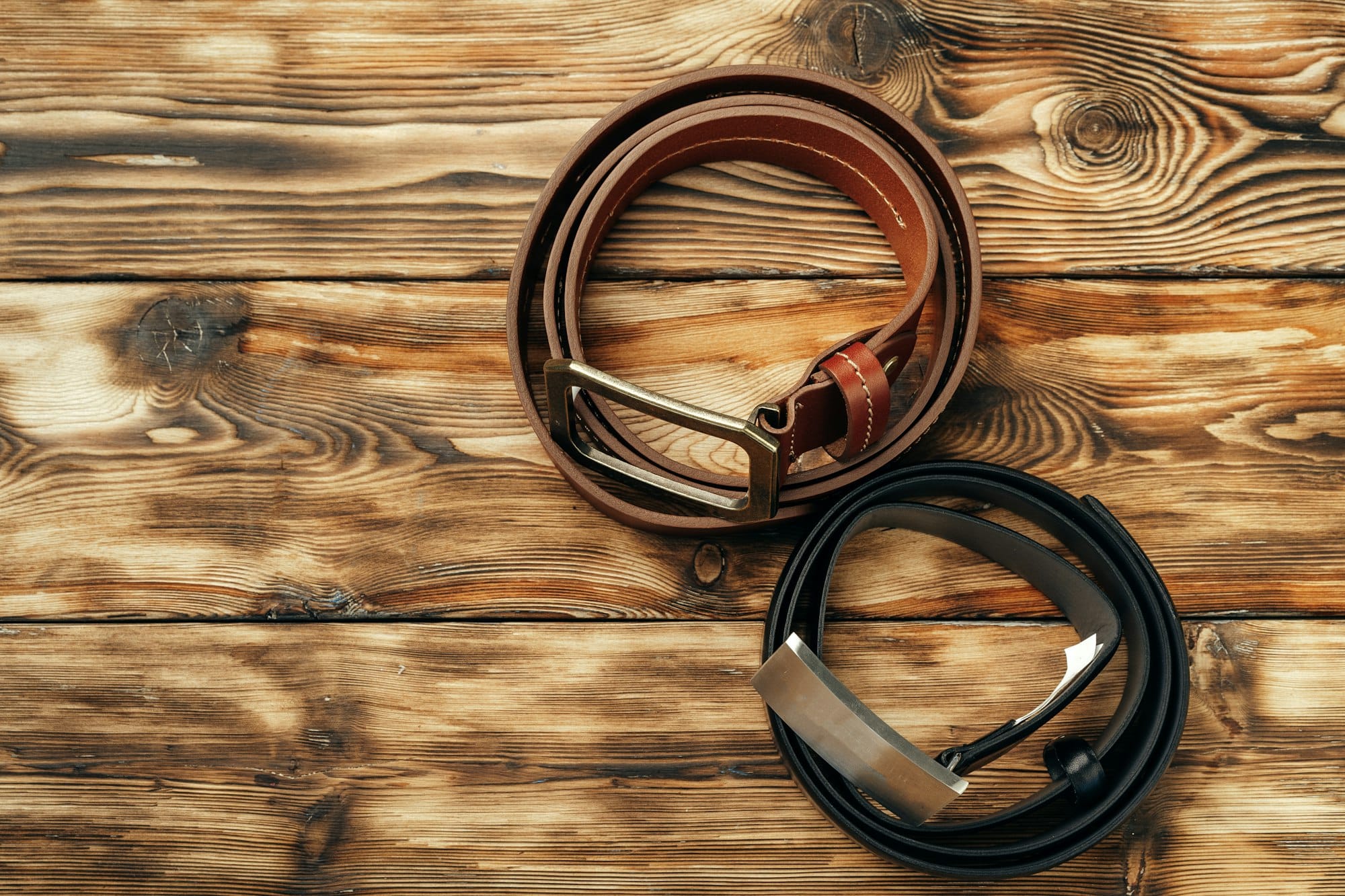 Fashionable male belt on brown wooden background